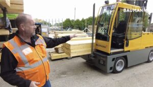Boční vysokozdvižný vozík Baumann při manipulaci s dlouhým materiálem ve výrobním provozu