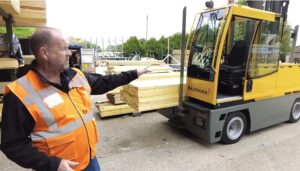 Boční vysokozdvižný vozík Baumann při manipulaci s dlouhým materiálem ve výrobním provozu